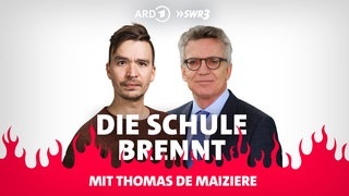 Thomas de Maizière und Bob Blume vor Flammen