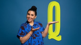 Ariana Baborie vor blauem Hintergrund und dem gelben Buchstaben "Q"