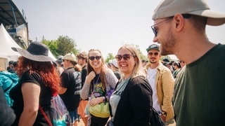 Eine junge Frau umgeben von vielen Festivalbesuchern warten darauf, das Gelände bei Rock am Ring betreten zu dürfen