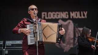 Matt Hansley von Flogging Molly steht mit seinem Akkordeon auf der Bühne bei Rock am Ring 2023