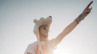 Ein junger Mann mit Sonnenbrille sitzt auf den Schultern eines anderen Mannes bei Rock am Ring 2023