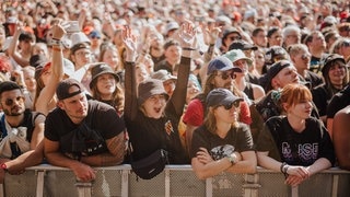 Eine junge Frau im Publikum reißt die Hände in die Höhe beim Auftritt von Yungblud bei Rock am Ring