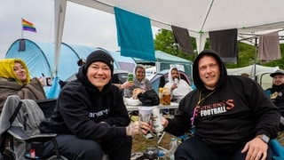 Zwei Personen stoßen mit Bier an