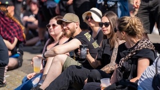 Vier Personen sitzen in der Sonne