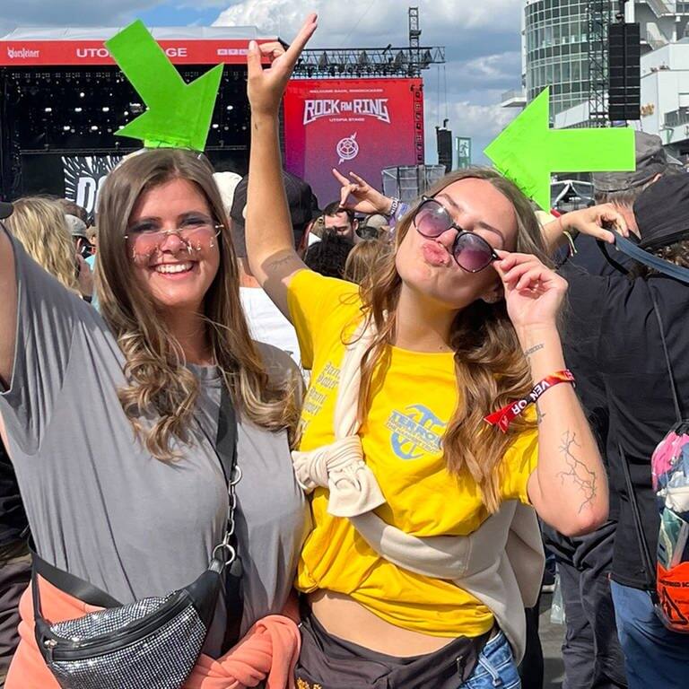 Zwei junge Frauen sind auf dem Musikfestival Rock am Ring und tragen selbst gestaltete Pfeile auf den Köpfen.