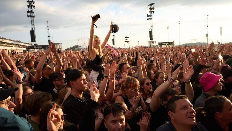 Beim Musikfestival Rock am Ring feiern die Menschen in der Menge.