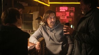 Tatort-Kritik Schwarzwald: Berg zeigt einem Mann in einer Bar ein Bild auf seinem Handy