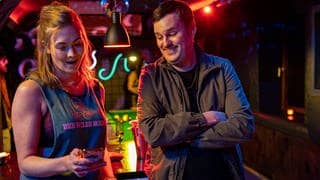 Tatort-Kritik Stuttgart: Eine Frau und ein Mann schauen auf ein Handy in einer Bar