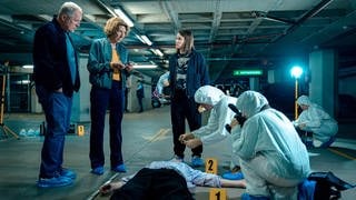 Tatort „Deine Mutter“ Wien: Die Kommissare stehen neben der Leiche und der Spurensicherung in einem Parkhaus