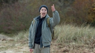 Szenenbilder aus dem Tatort „Borowski und das ewige Meer“. Benno, ein Tatverdächtiger steht wütend am Strand und hebt die Hand. Tatort-Checker Michael Haas spricht in seiner Kritik von einem „gechillten und zarten“ Krimi, obwohl es gleich eine ganze Mordserie gibt!