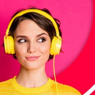 Frau hört Audioreihen und Podcast auf dem Kopfhörer